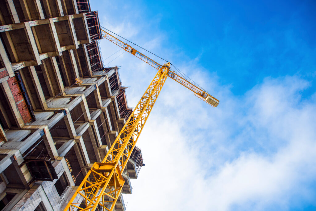 construction site and yellow crane on the background blue sky